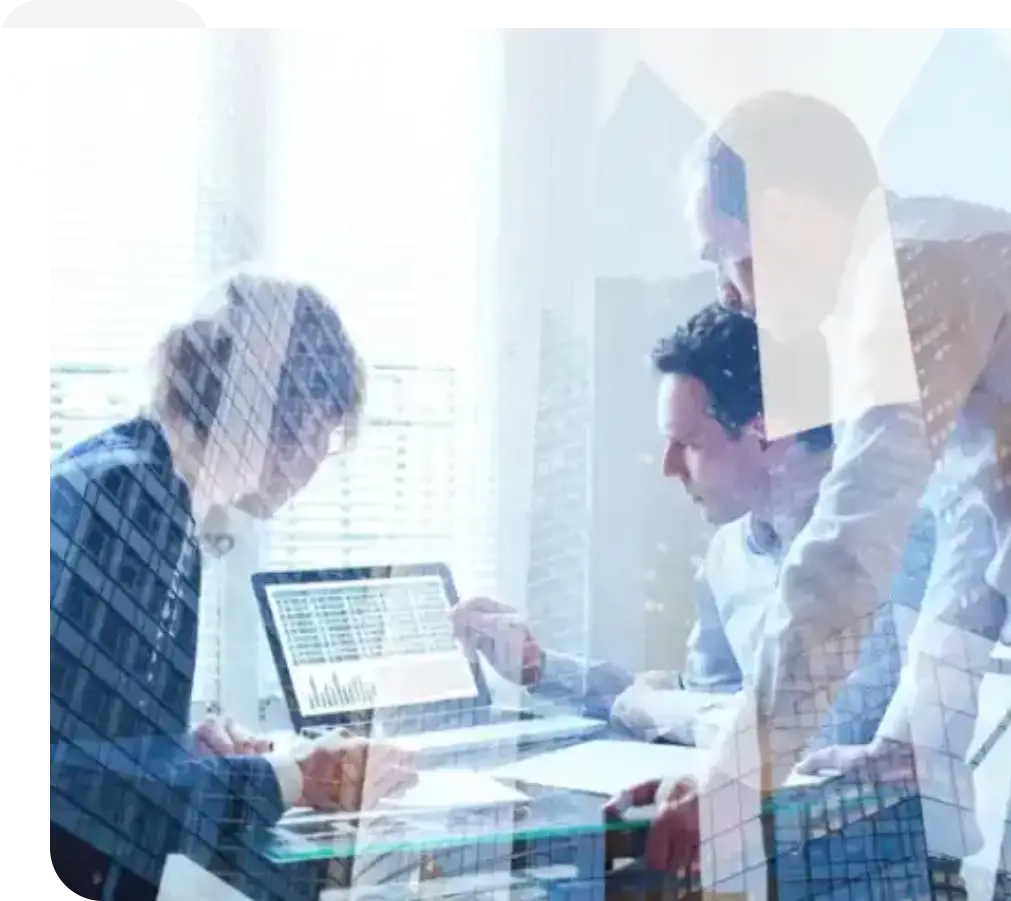 A group of people sitting around a table with laptops.