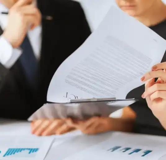 A group of people sitting at tables with papers.